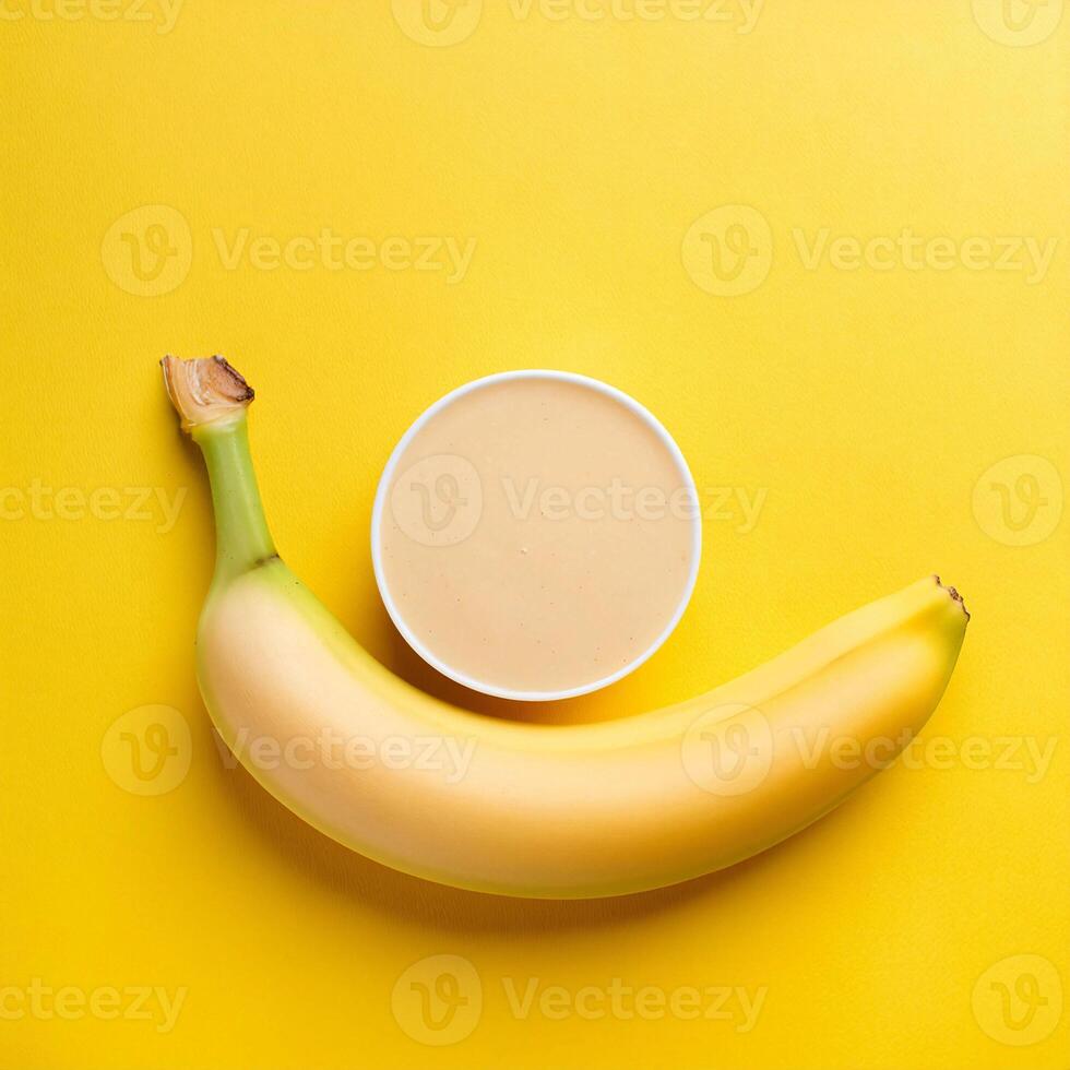 uma banana e uma copo do iogurte em uma amarelo fundo foto