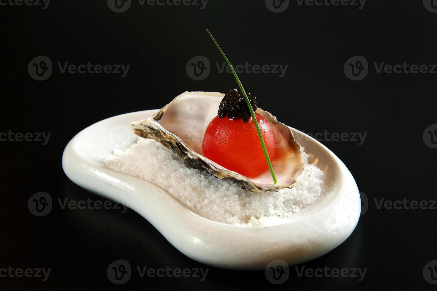 Melancia bola com caviar dentro ostra com sal foto