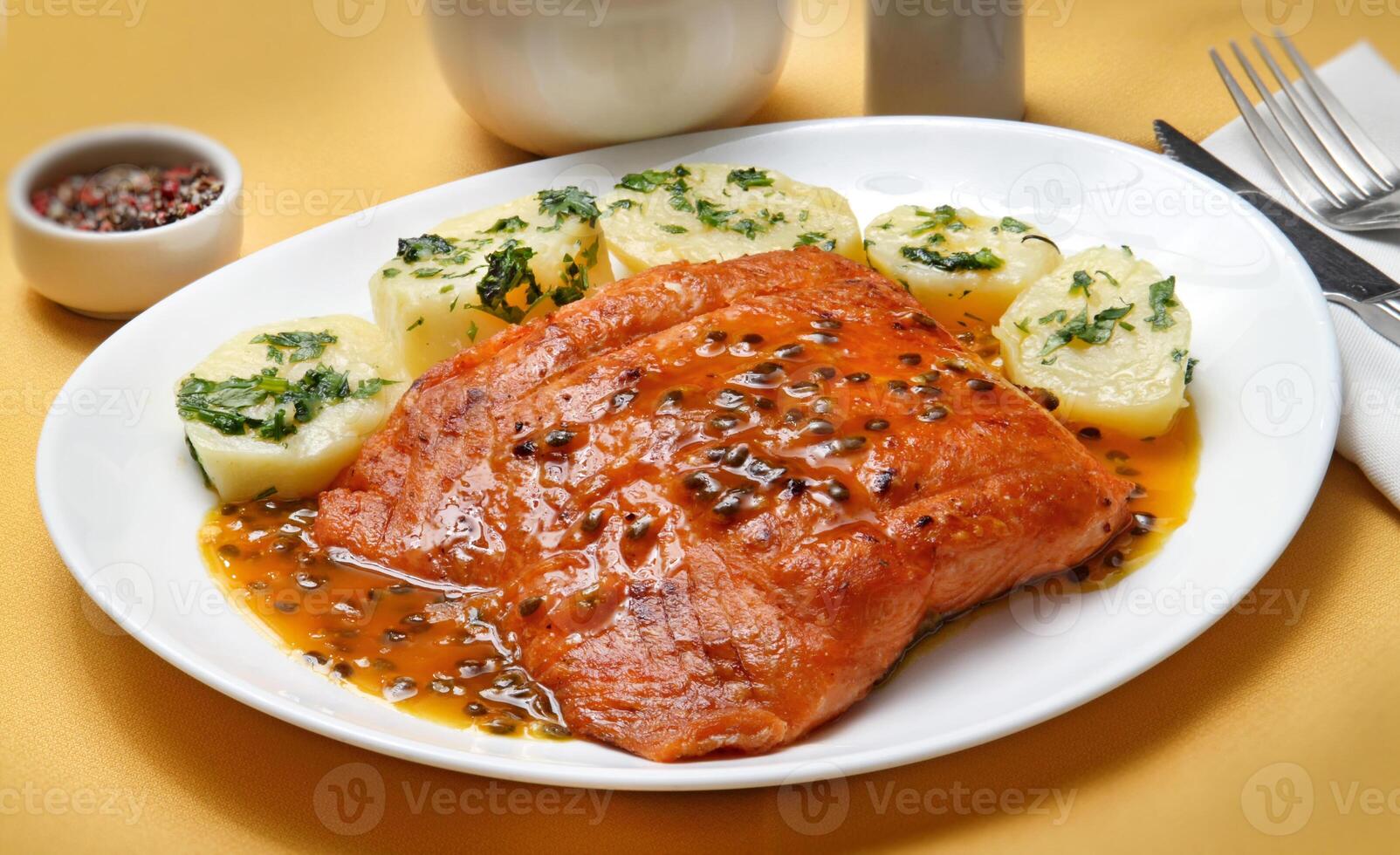 grelhado salmão com alcaparras, batatas e paixão fruta molho foto