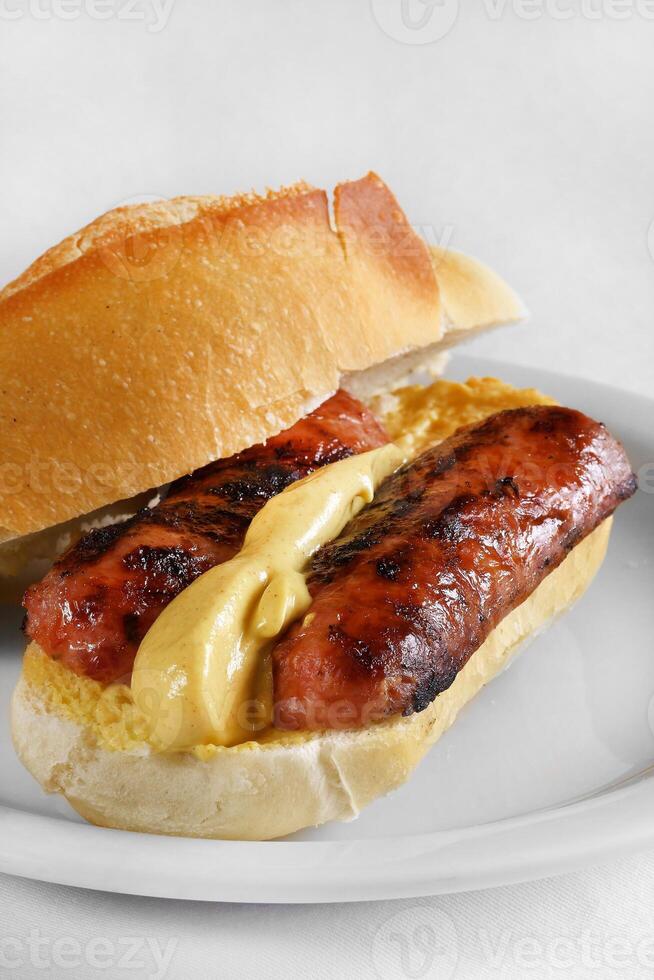 choripan, calabresa linguiça sanduíche com mostarda em francês pão foto