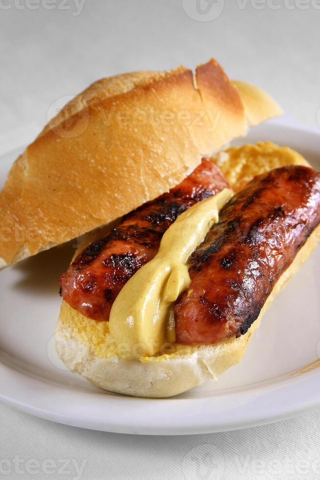 choripan, calabresa linguiça sanduíche com mostarda em francês pão foto