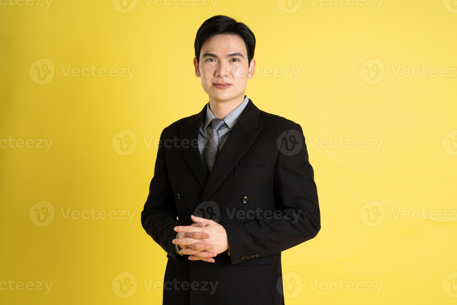 retrato do ásia masculino homem de negocios. vestindo uma terno e posando em uma amarelo fundo foto