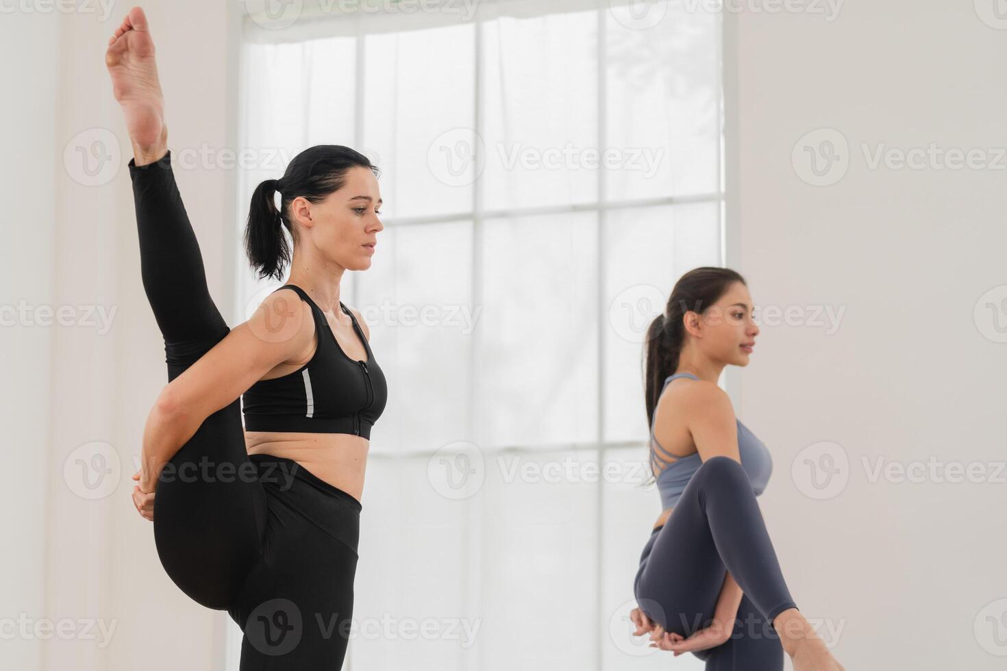 uma jovem em forma mulher práticas ioga de fazendo asanas dentro uma brilhante ioga estúdio. ioga praticante com alunos dentro ioga aula. foto