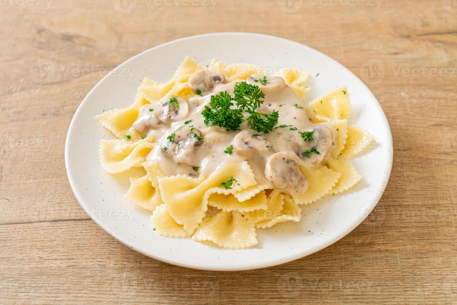 macarrão farfalle com molho de creme de cogumelos branco foto