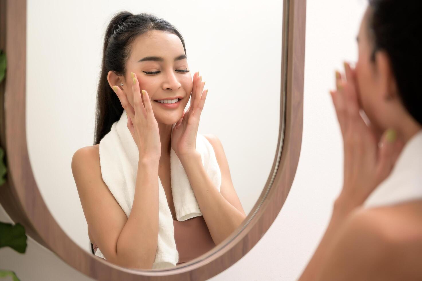 lindo ásia mulher é lavando e limpeza dela face foto