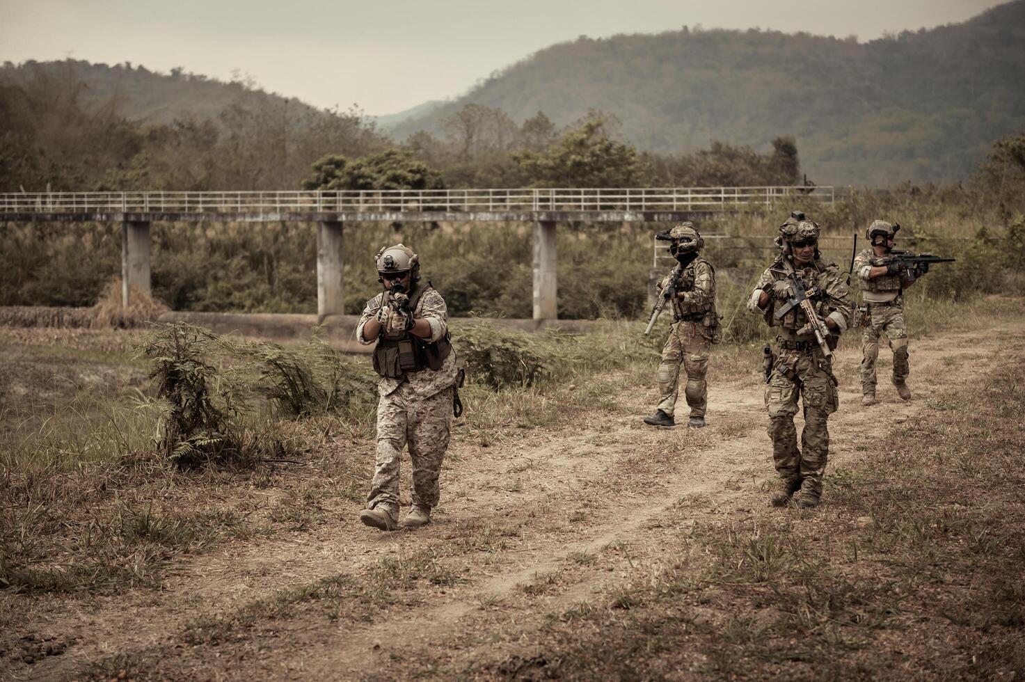 soldados dentro camuflar uniformes visando com seus rifles prontos para fogo durante militares Operação dentro a floresta soldados Treinamento dentro uma militares Operação foto