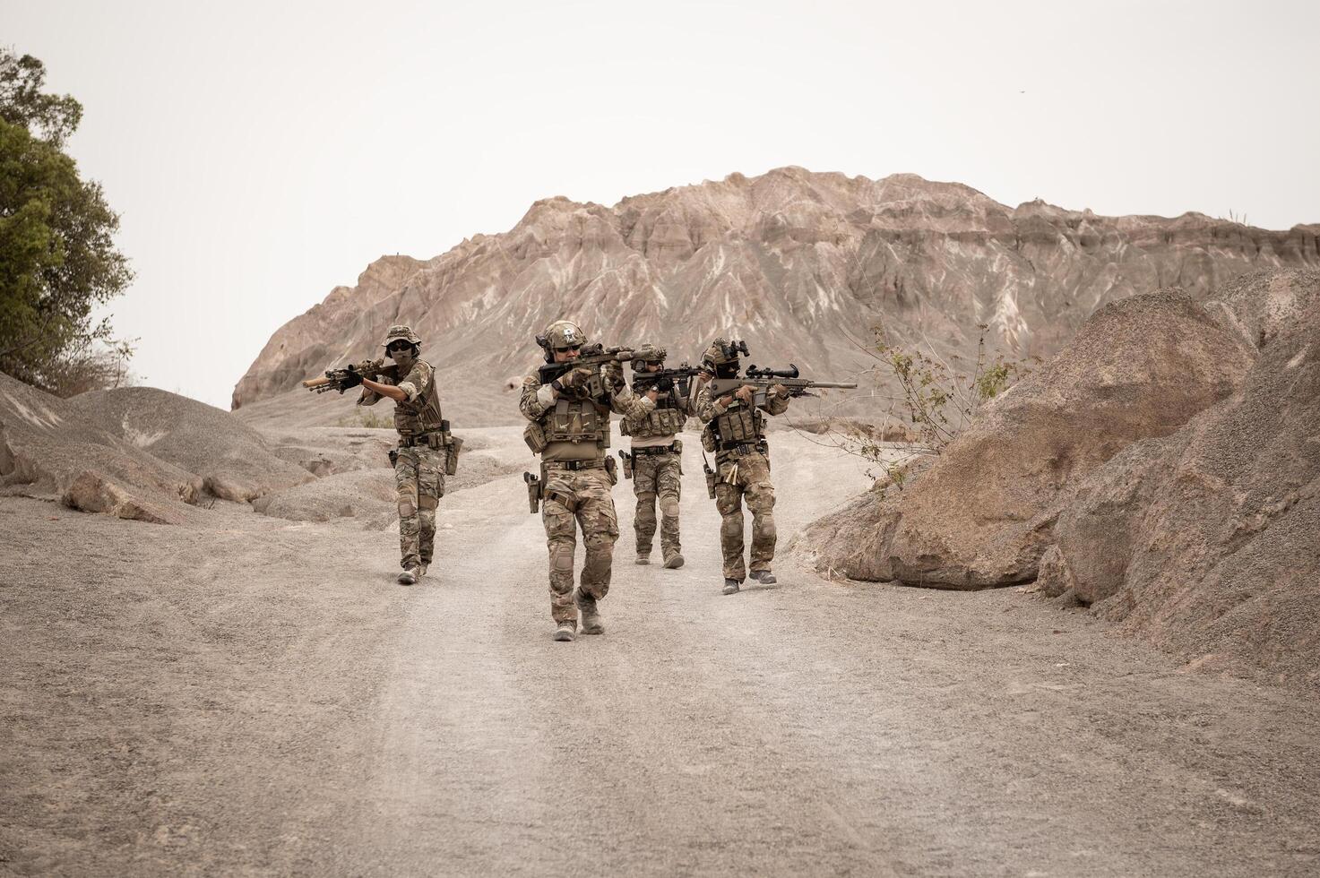 soldados dentro camuflar uniformes visando com seus rifles prontos para fogo durante militares Operação dentro a deserto soldados Treinamento dentro uma militares Operação foto