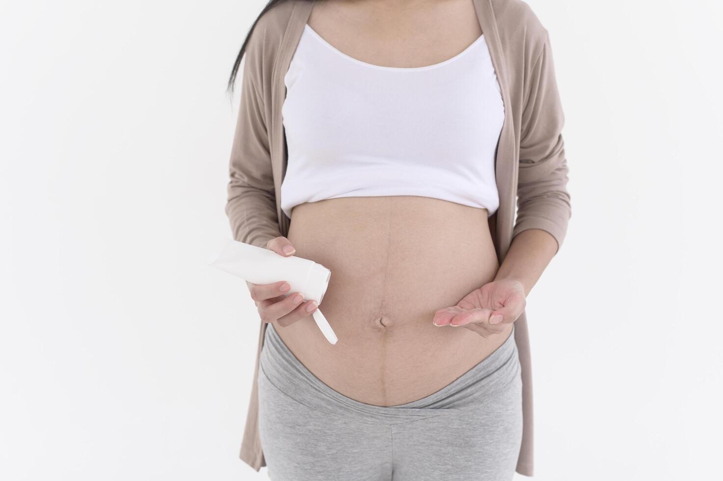 lindo grávida mulher aplicando hidratante, esticam marca creme em barriga, fertilidade infertilidade tratamento, fertilização in vitro, futuro maternidade conceito foto