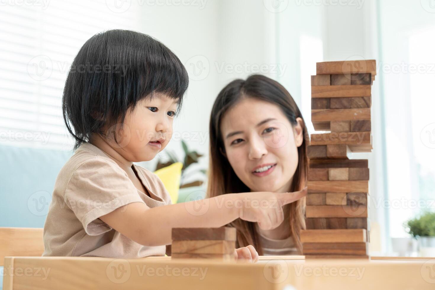 Ásia feliz solteiro mãe jogando Aprendendo jogos janga com a pequeno garoto. engraçado família é feliz e animado dentro a casa. pai e filho tendo Diversão gastos Tempo junto. feriado, fim de semana, vago. foto