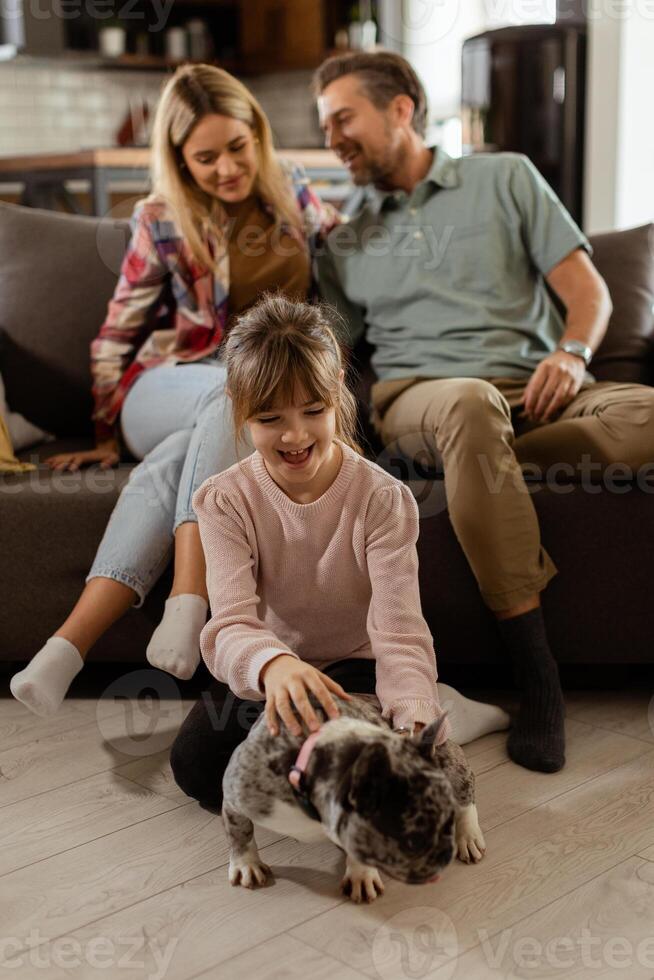 família vínculo Tempo com brincalhão francês buldogue filhote dentro acolhedor vivo quarto foto