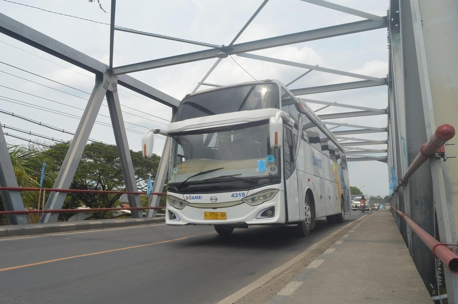 uma ampla damri ônibus estava passagem em a ferro treliça ponte, Indonésia, 16 janeiro 2024. foto