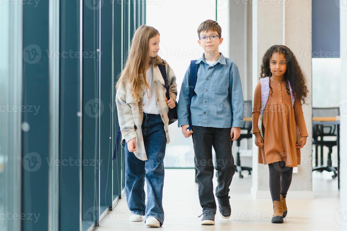 grupo do elementar escola crianças dentro uma escola corredor foto