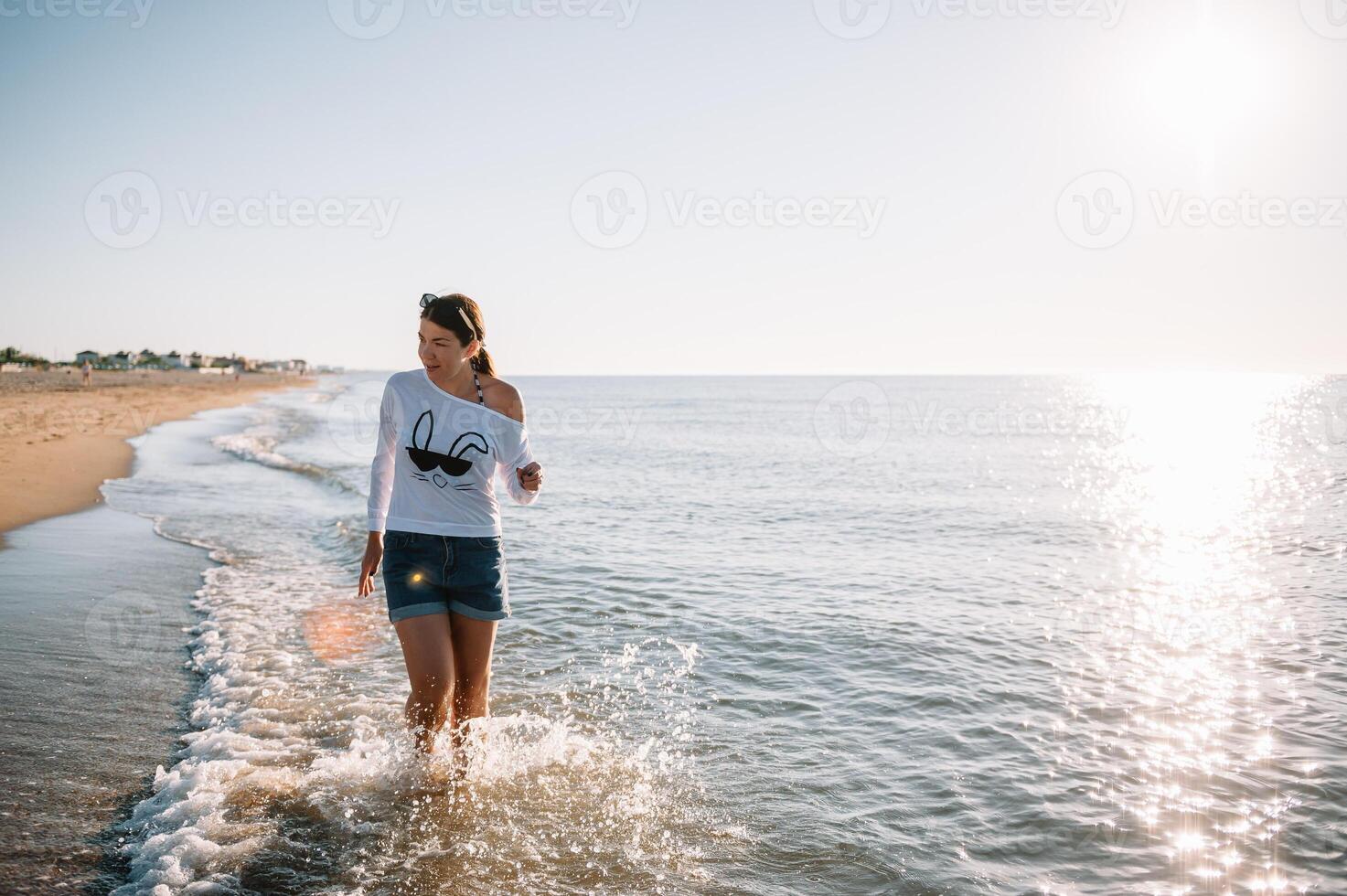 lindo menina com bonita pernas caminhando ao longo a Beira Mar dentro a verão quente dia perto a mar. foto