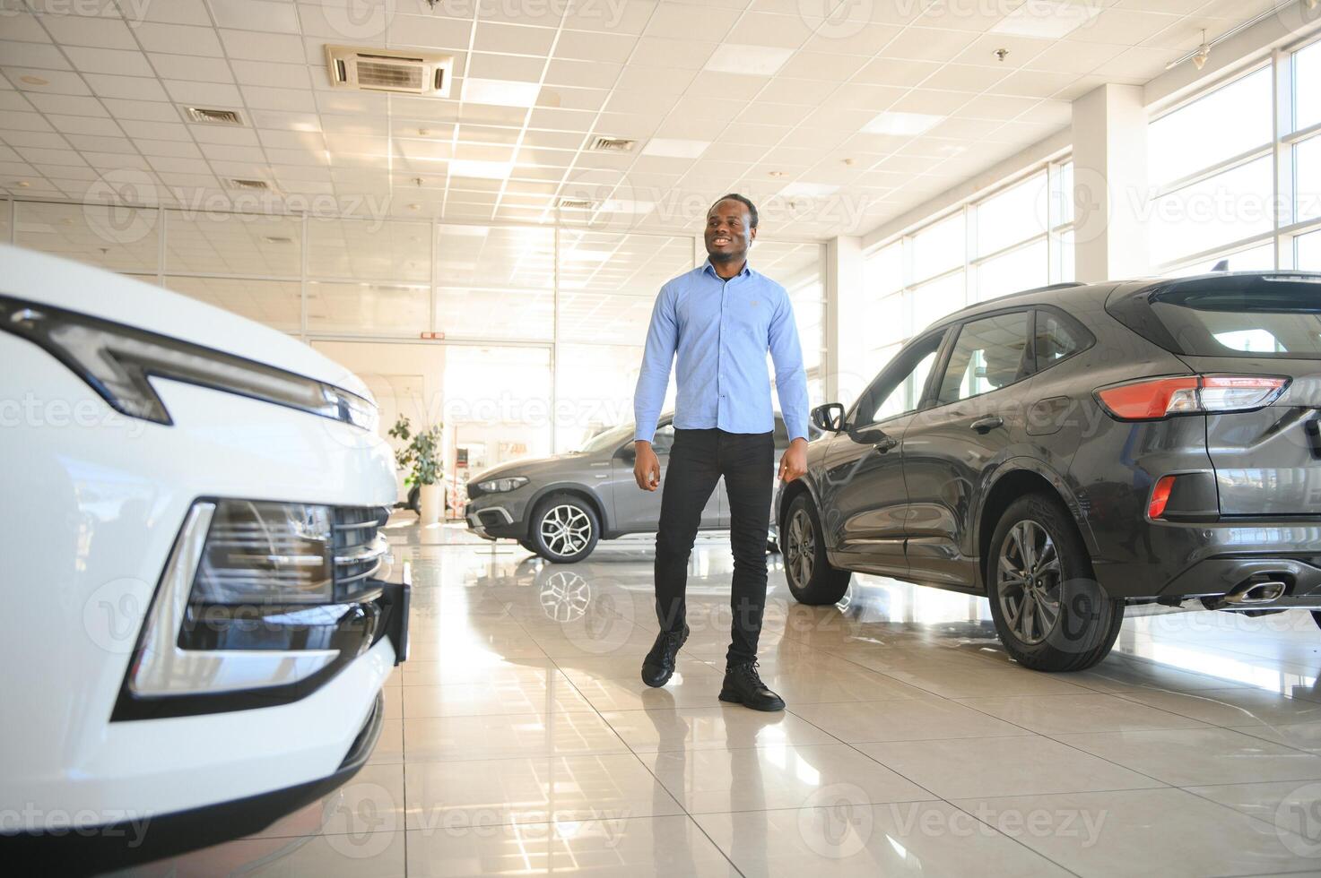 carro comprador. Preto cara escolhendo Novo automóvel dentro concessionária loja foto