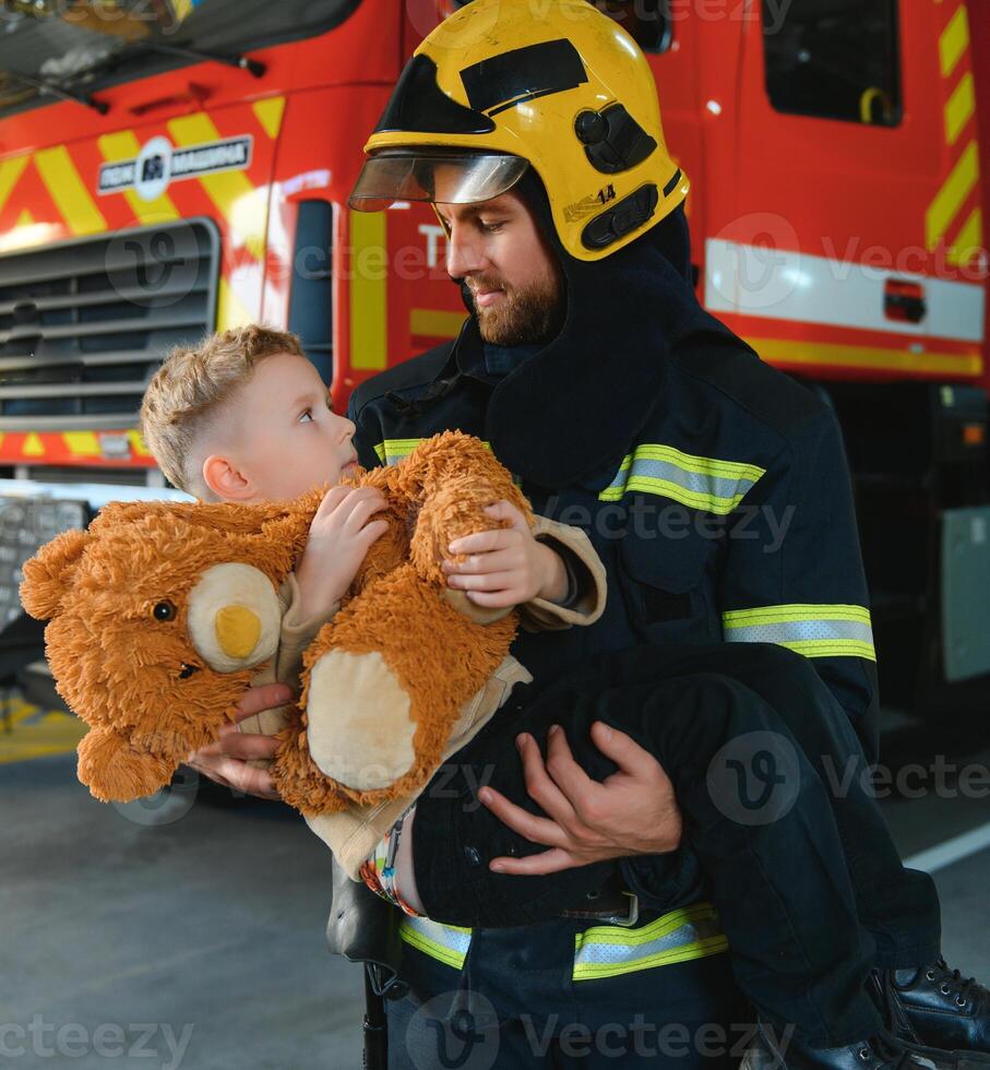 bombeiro segurando criança Garoto para Salve  ele dentro fogo e fumaça, bombeiros resgate a Rapazes a partir de fogo foto