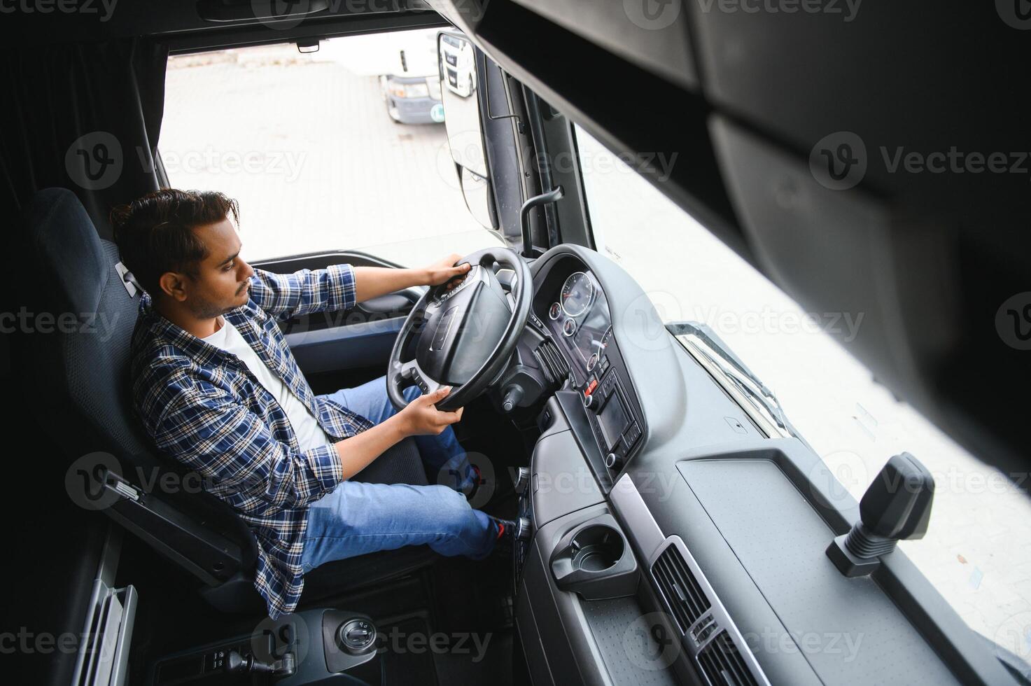 uma jovem indiano masculino caminhão motorista senta atrás a roda foto