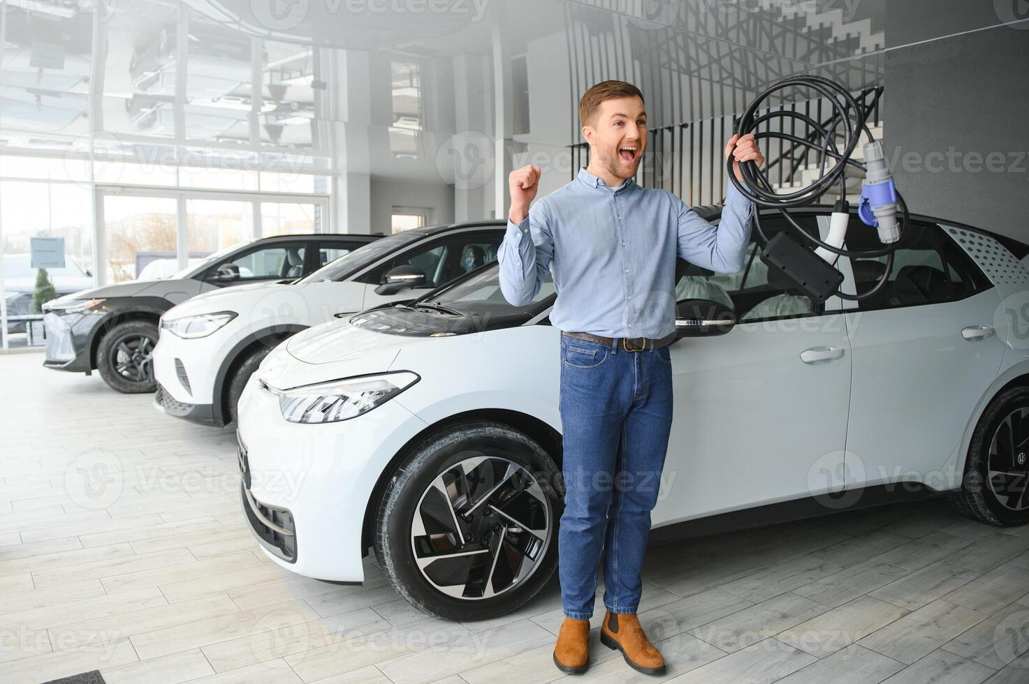 conceito do comprando elétrico veículo. bonito o negócio homem carrinhos perto elétrico carro às concessionária foto