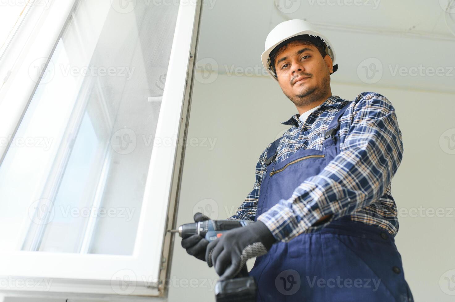 indiano construção trabalhador instalando janela dentro casa. foto