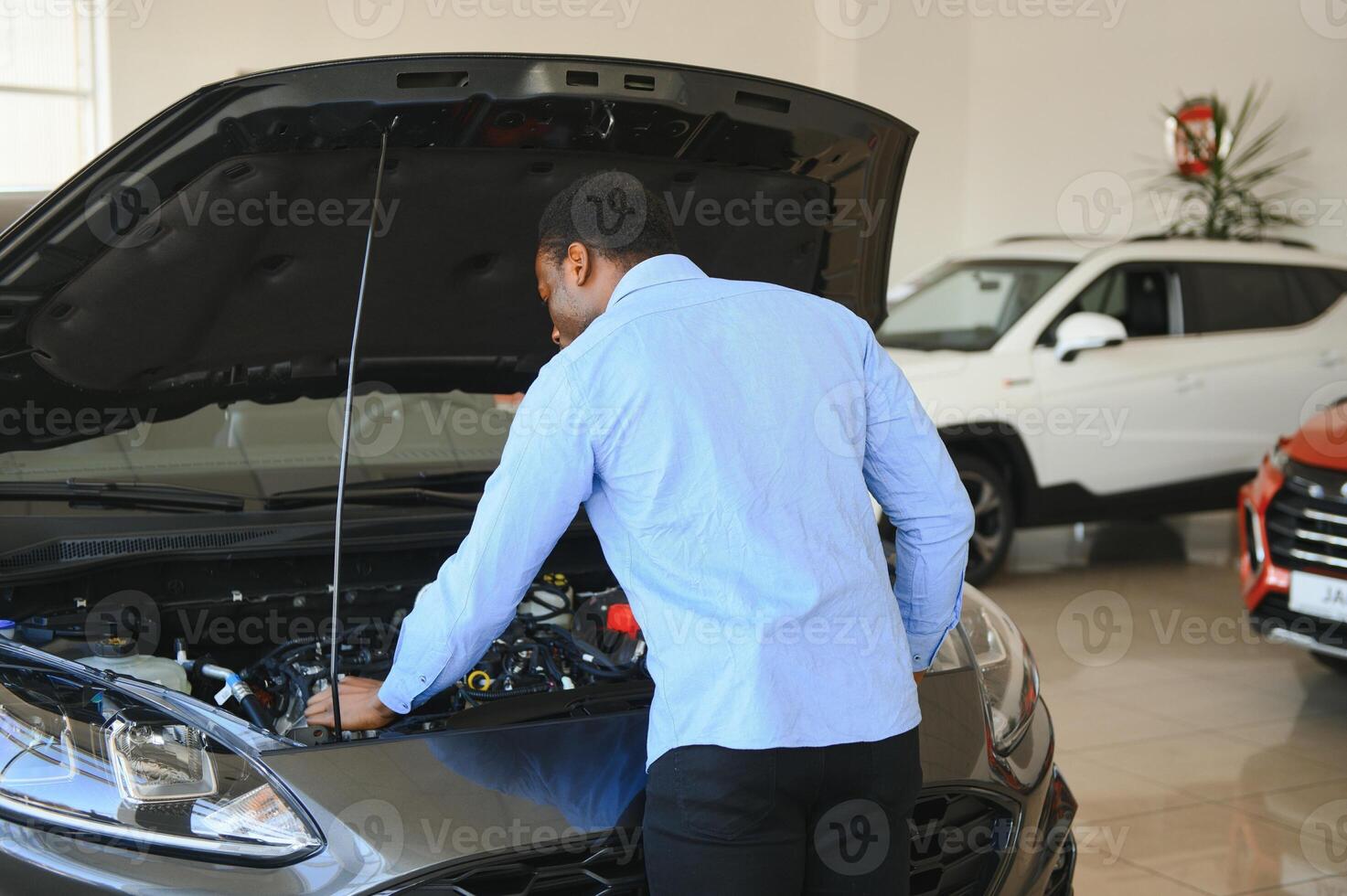 carro comprador. Preto cara escolhendo Novo automóvel dentro concessionária loja foto