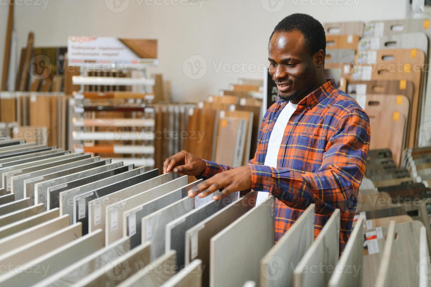 africano americano homem cliente escolhendo cerâmico telha às construção materiais loja foto