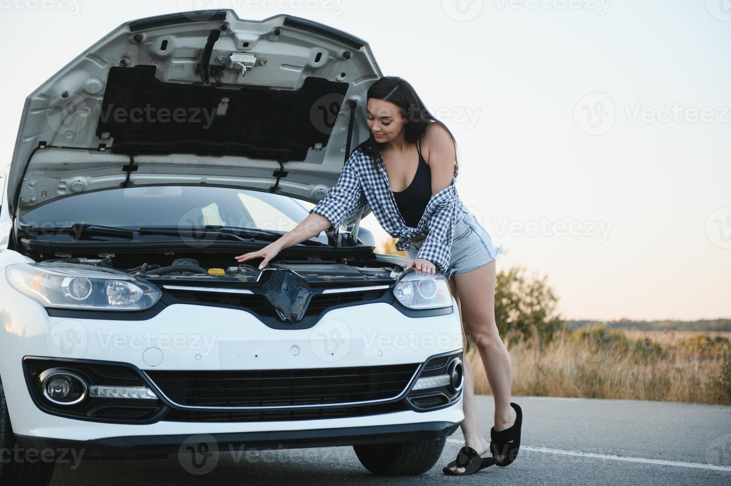 lindo sexy mulher perto uma quebrado carro. confuso mulher faz não conhecer o que para Faz foto