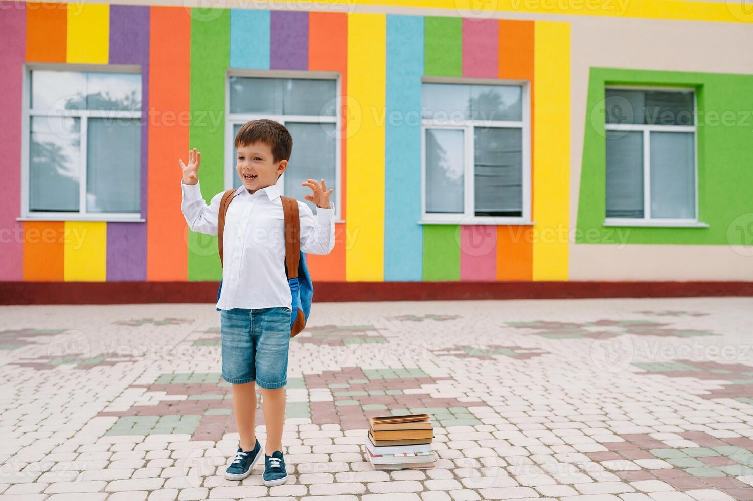 costas para escola. feliz sorridente Garoto dentro óculos é indo para escola para a primeiro tempo. criança com mochila e livro ao ar livre. começando do aulas. primeiro dia do outono foto