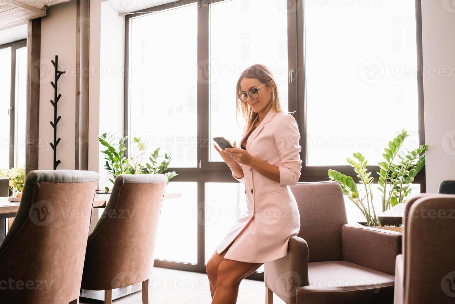 o negócio mulher em a telefone às escritório. jovem o negócio mulher tendo telefone ligar às a escritório. sorridente o negócio mulher. bonita jovem o negócio usando Smartphone às a loft escritório. foto