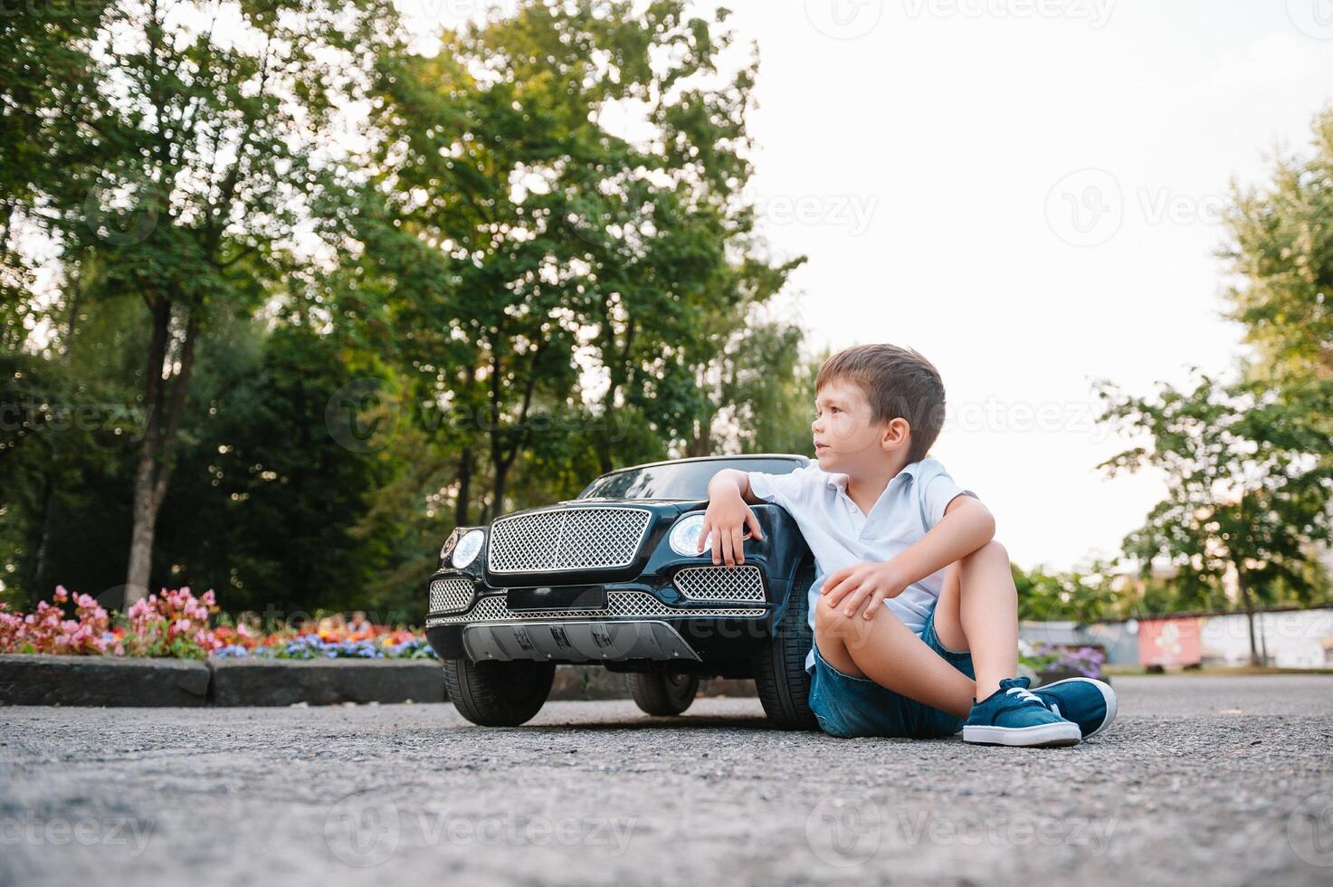 fofa Garoto dentro equitação uma Preto elétrico carro dentro a parque. engraçado Garoto passeios em uma brinquedo elétrico carro. cópia de espaço. foto