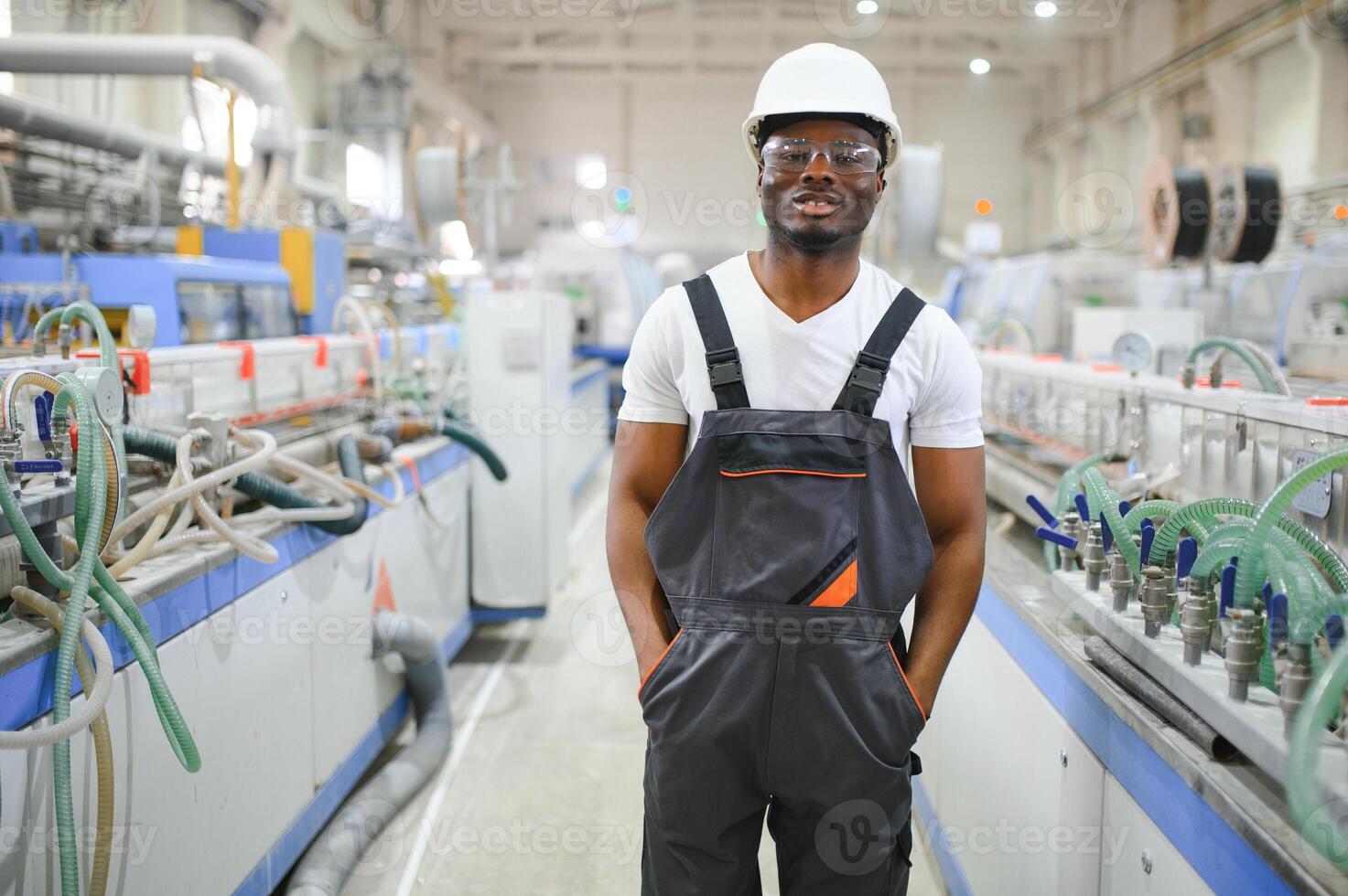 profissional pesado indústria engenheiro trabalhador vestindo uniforme, óculos e Difícil chapéu dentro uma fábrica foto