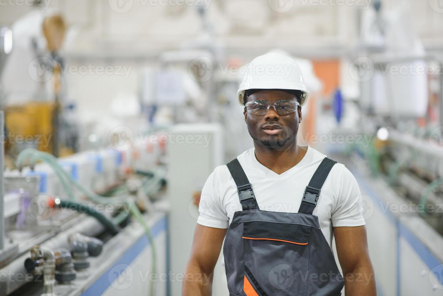 profissional pesado indústria engenheiro trabalhador vestindo uniforme, óculos e Difícil chapéu dentro uma fábrica foto