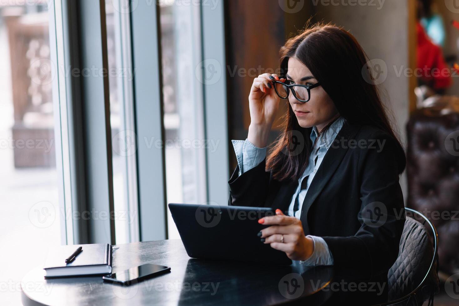 feliz jovem empresária usando tábua computador dentro uma cafeteria. seletivo foco foto