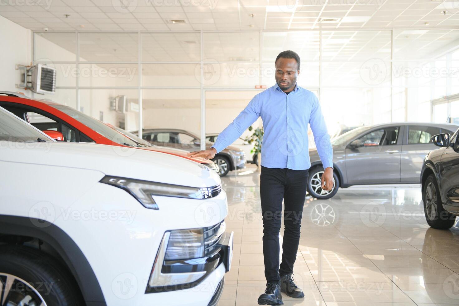 carro comprador. Preto cara escolhendo Novo automóvel dentro concessionária loja foto