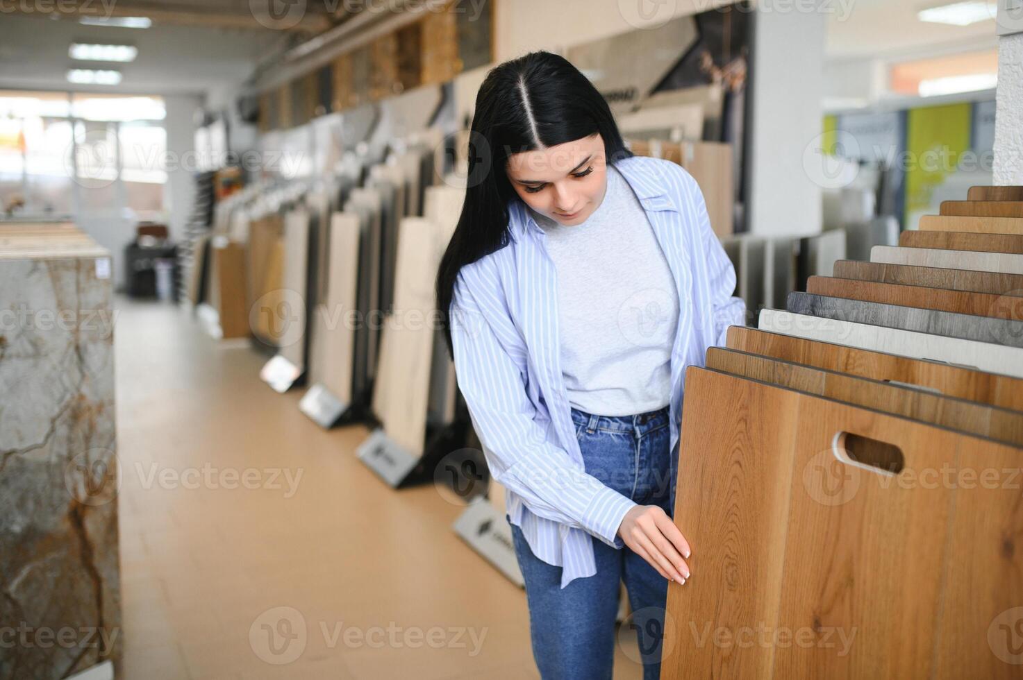 mulher escolhendo laminado chão Projeto a partir de amostras dentro pavimentos loja foto