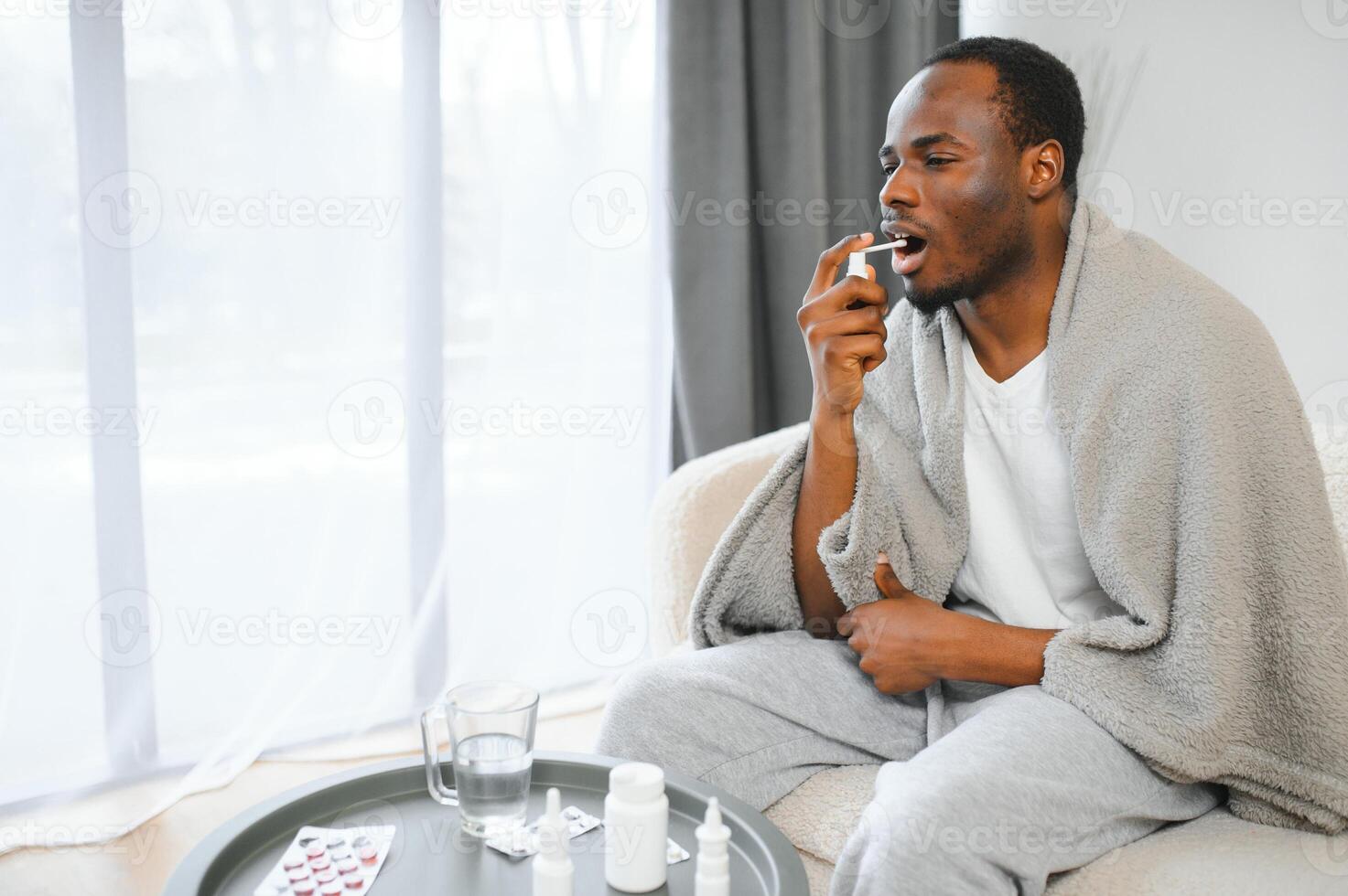 doente africano homem usando garganta spray às casa foto