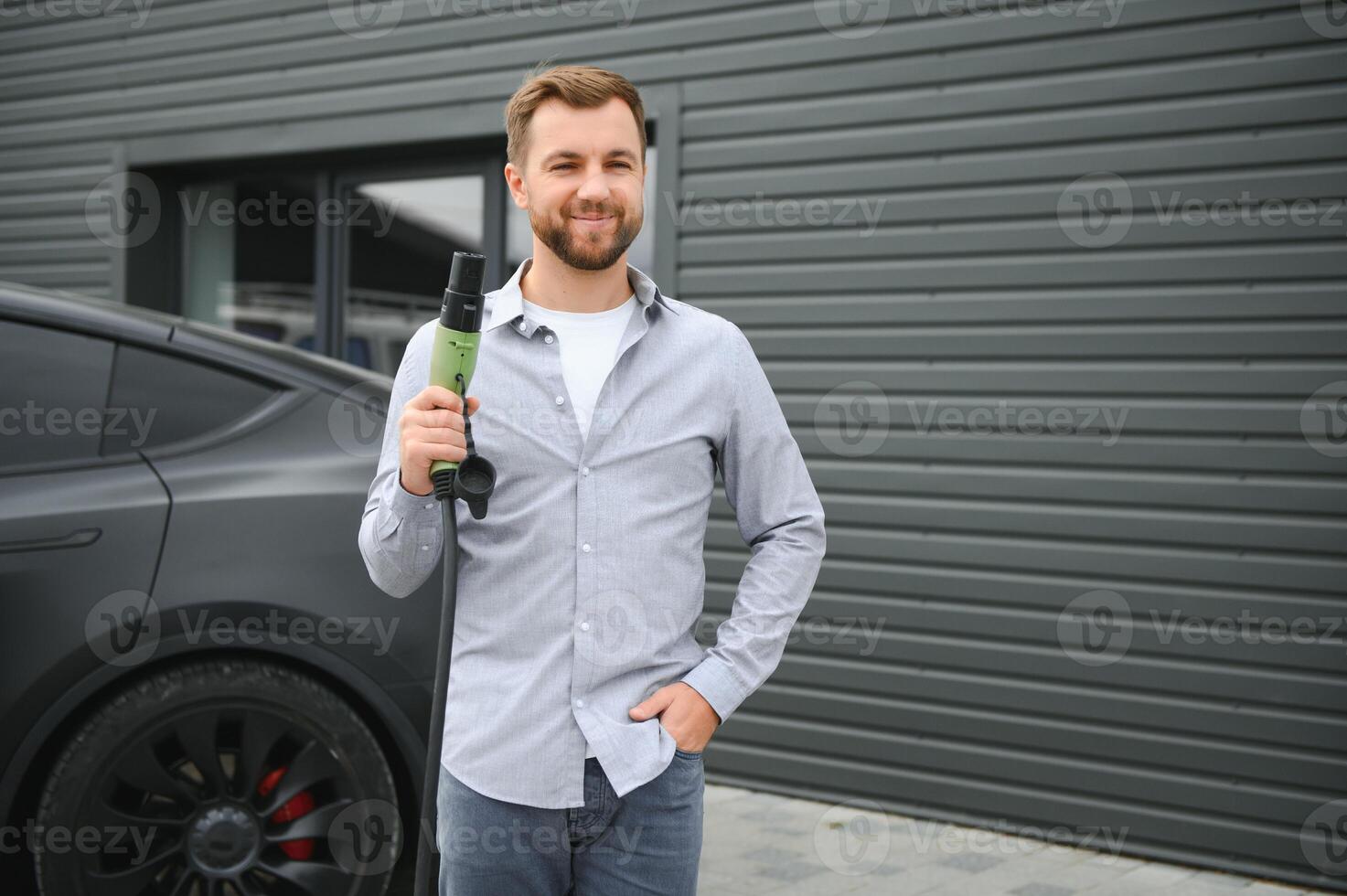 uma homem cobranças a elétrico carro foto