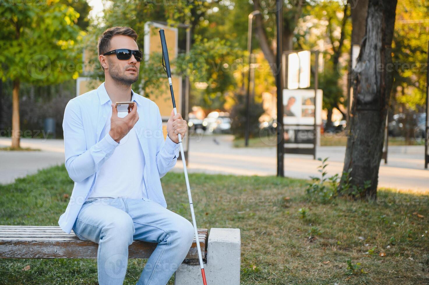 jovem cego homem usando telefone e enviando voz mensagem foto