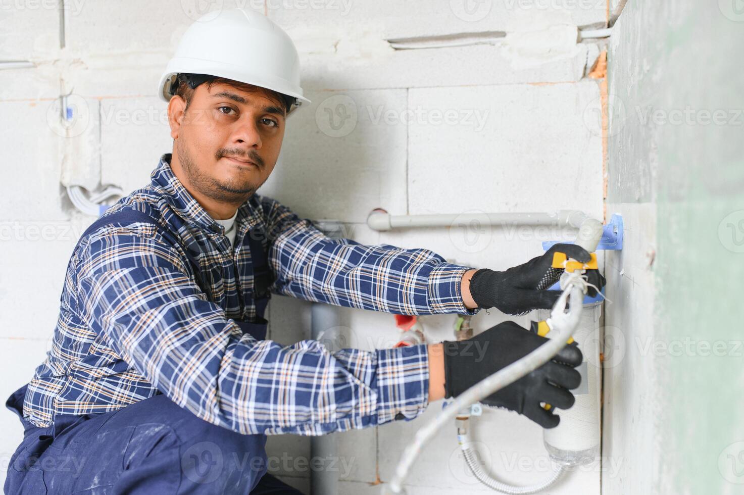 indiano encanador instalando água equipamento - metro, filtro e pressão redutor foto