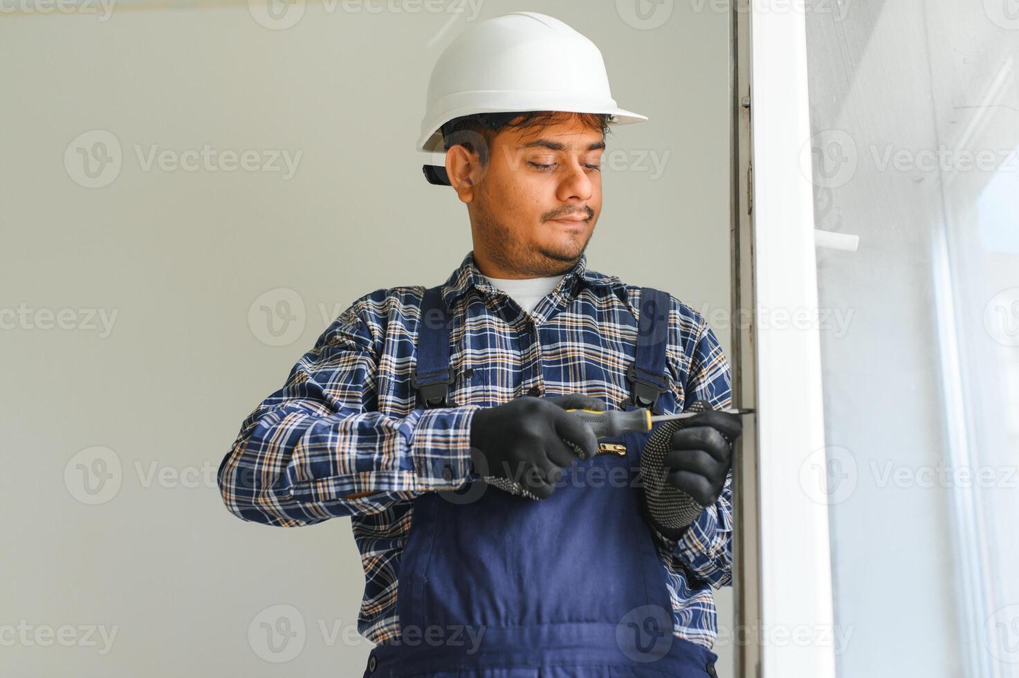 indiano construção trabalhador instalando janela dentro casa. foto