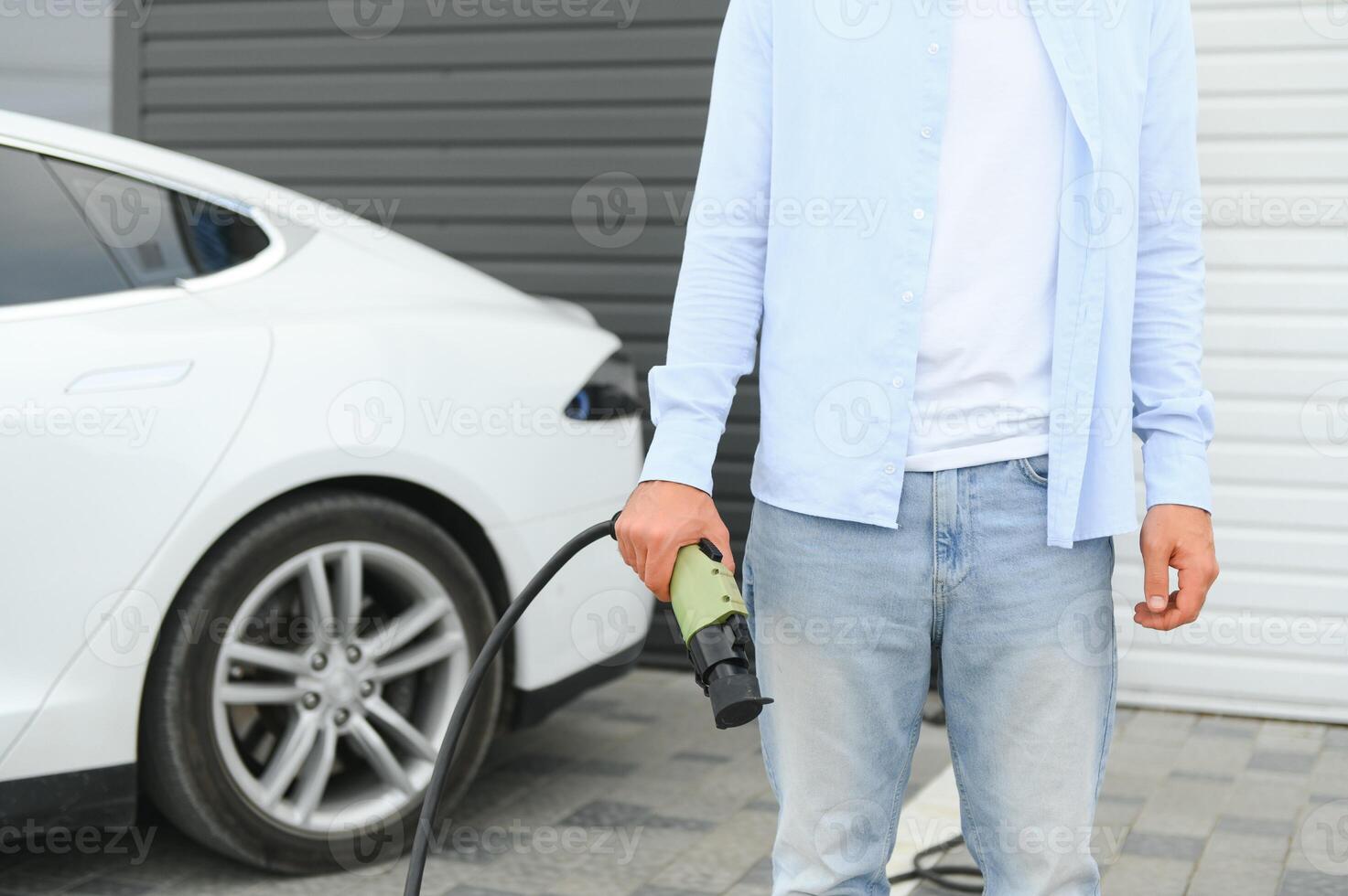 fechar acima do mão segurando poder cabo para ambientalmente amigáveis zero emissão elétrico carro foto