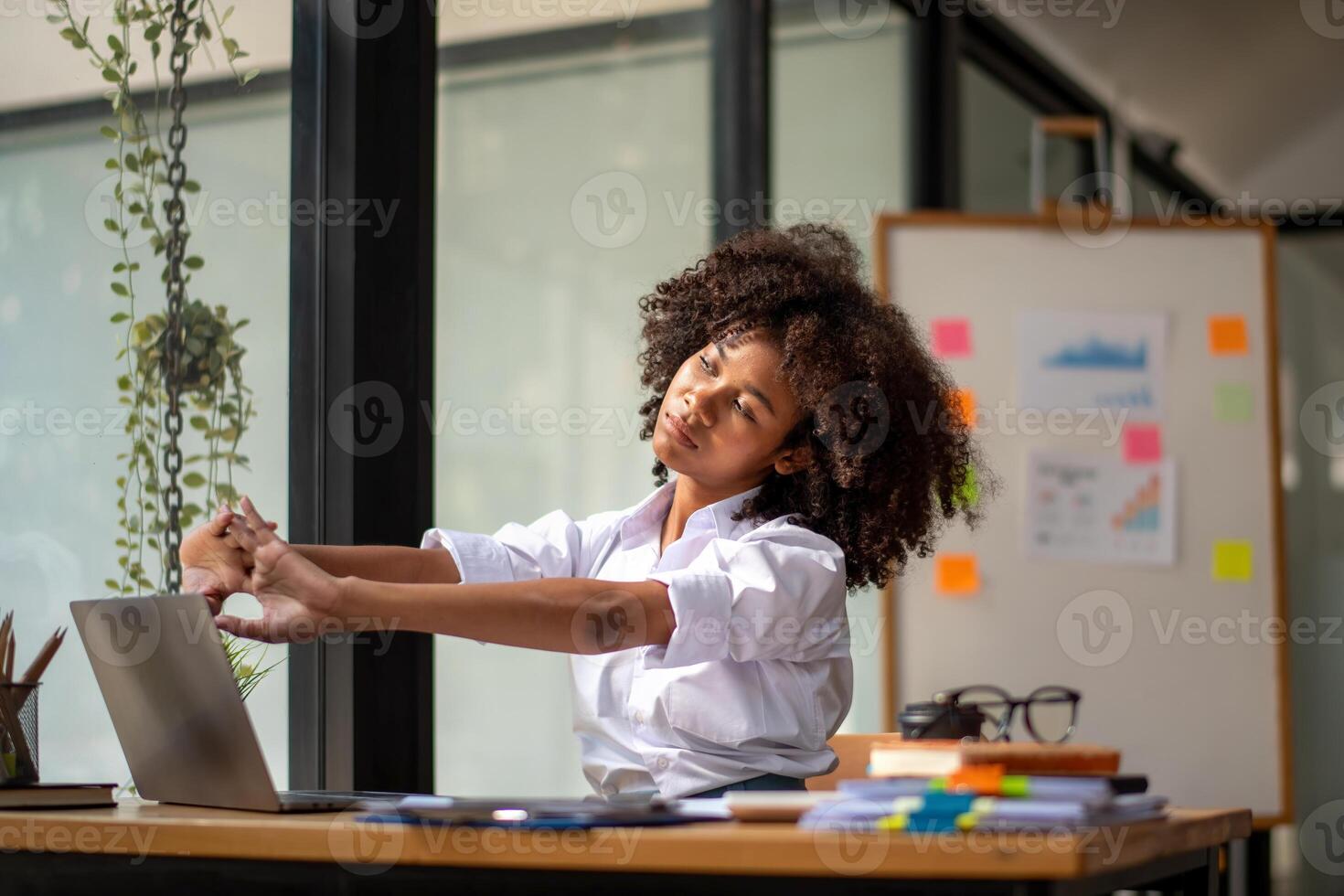 Preto mulher obtendo fisicamente ativo a partir de fadiga sentado às uma escrivaninha. cansado a partir de trabalhar, torção vencimento para dor, escritório síndrome do escritório trabalhadores foto