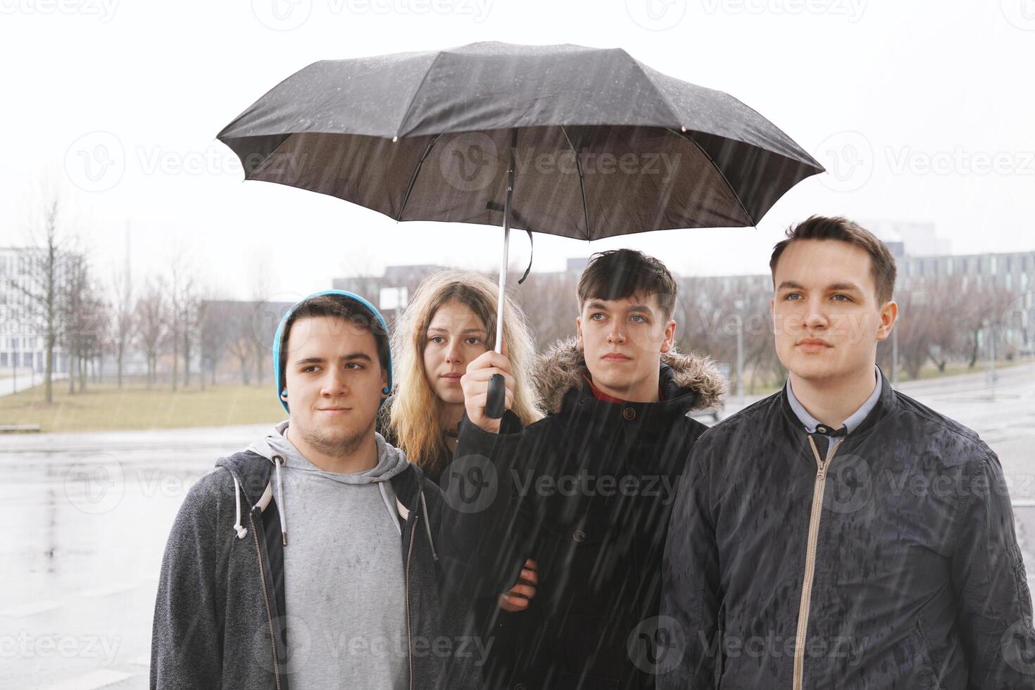 grupo do jovem urbano Adolescência amigos debaixo 1 guarda-chuva foto