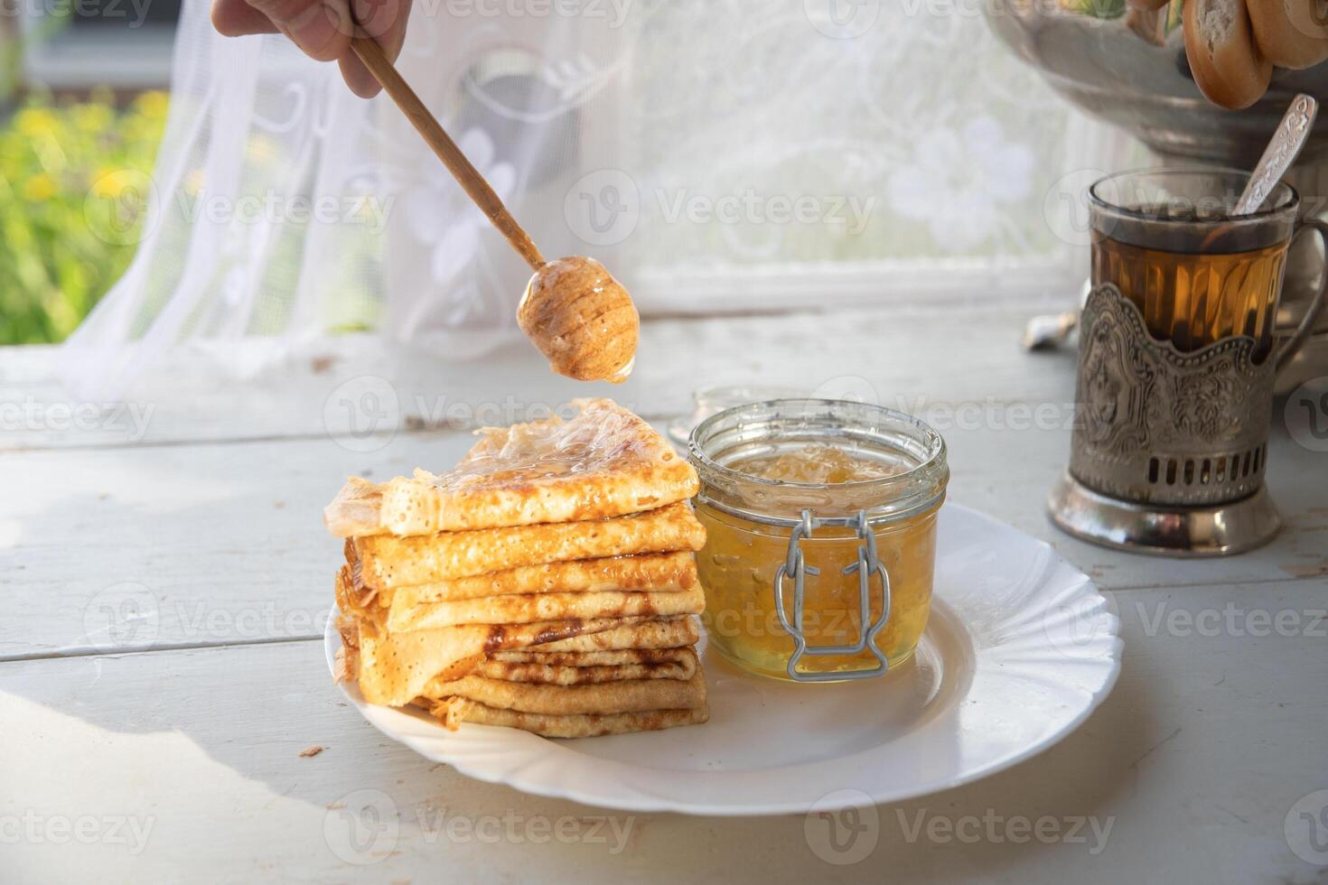 russo panquecas com querida e uma copo do chá a partir de uma vintage samovar maslenitsa festival conceito foto