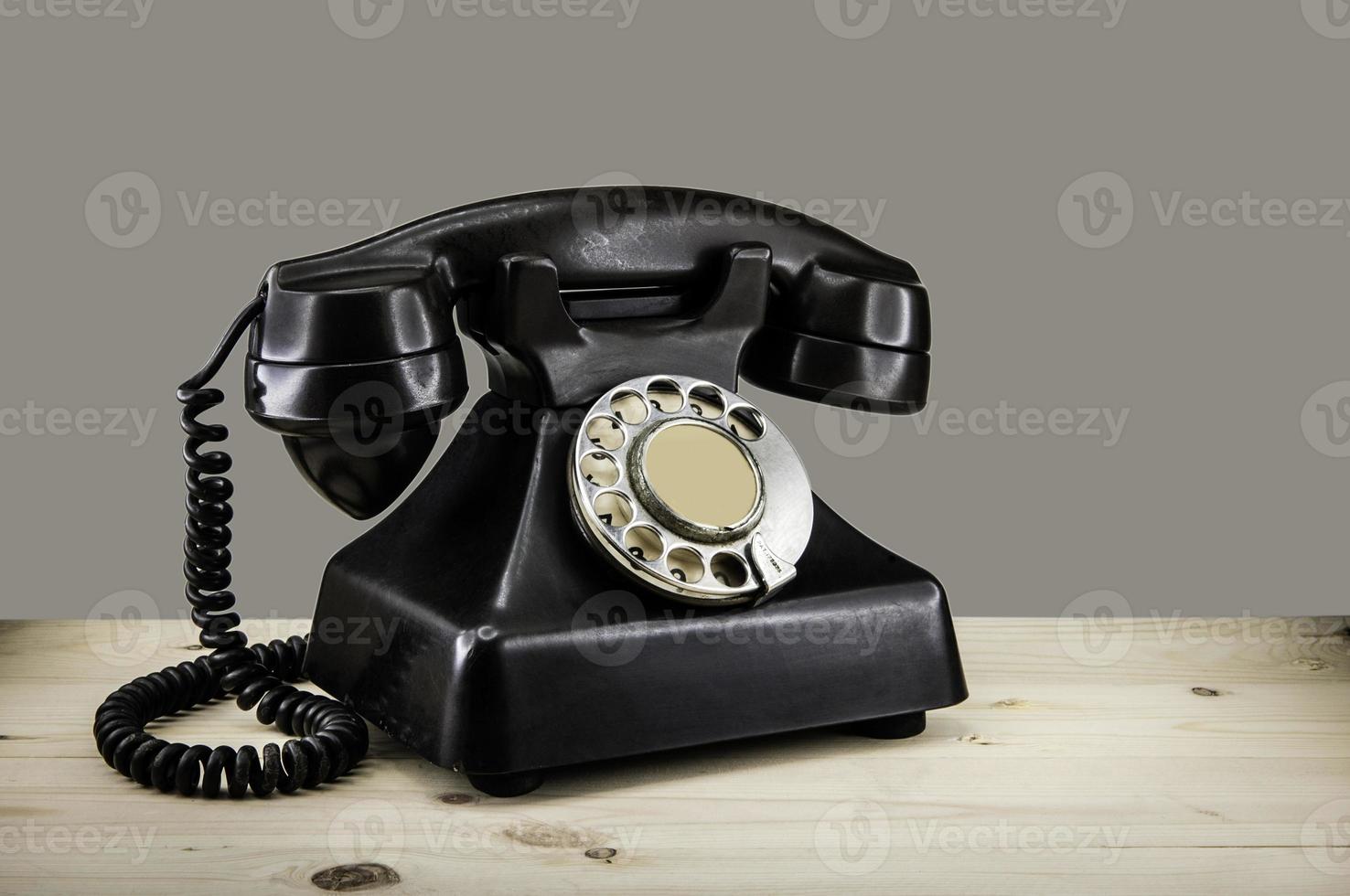 telefone vintage antigo com disco giratório no fundo do grunge da mesa de madeira foto