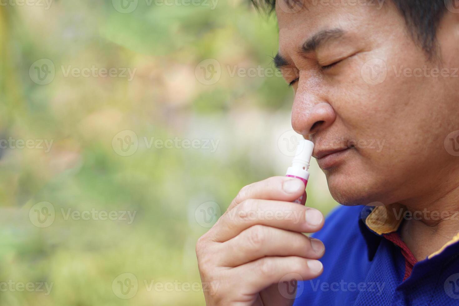 ásia homem usar mentol inalador para cheiro para alívio sintoma do tonto a partir de quente clima doença. conceito, auto primeiro ajuda para proteger a partir de calor AVC. refrescante. aroma terapia. foto