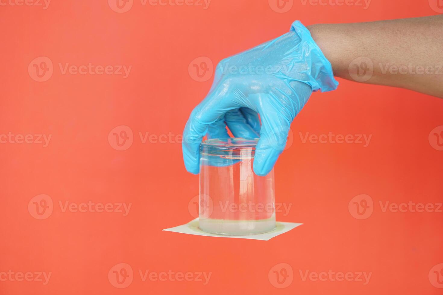 fechar-se mão aguarde e virar uma vidro do água sobre abaixo. coberto a vidro com papel. conceito, Ciência experimentar sobre ar e líquido pressão. foto