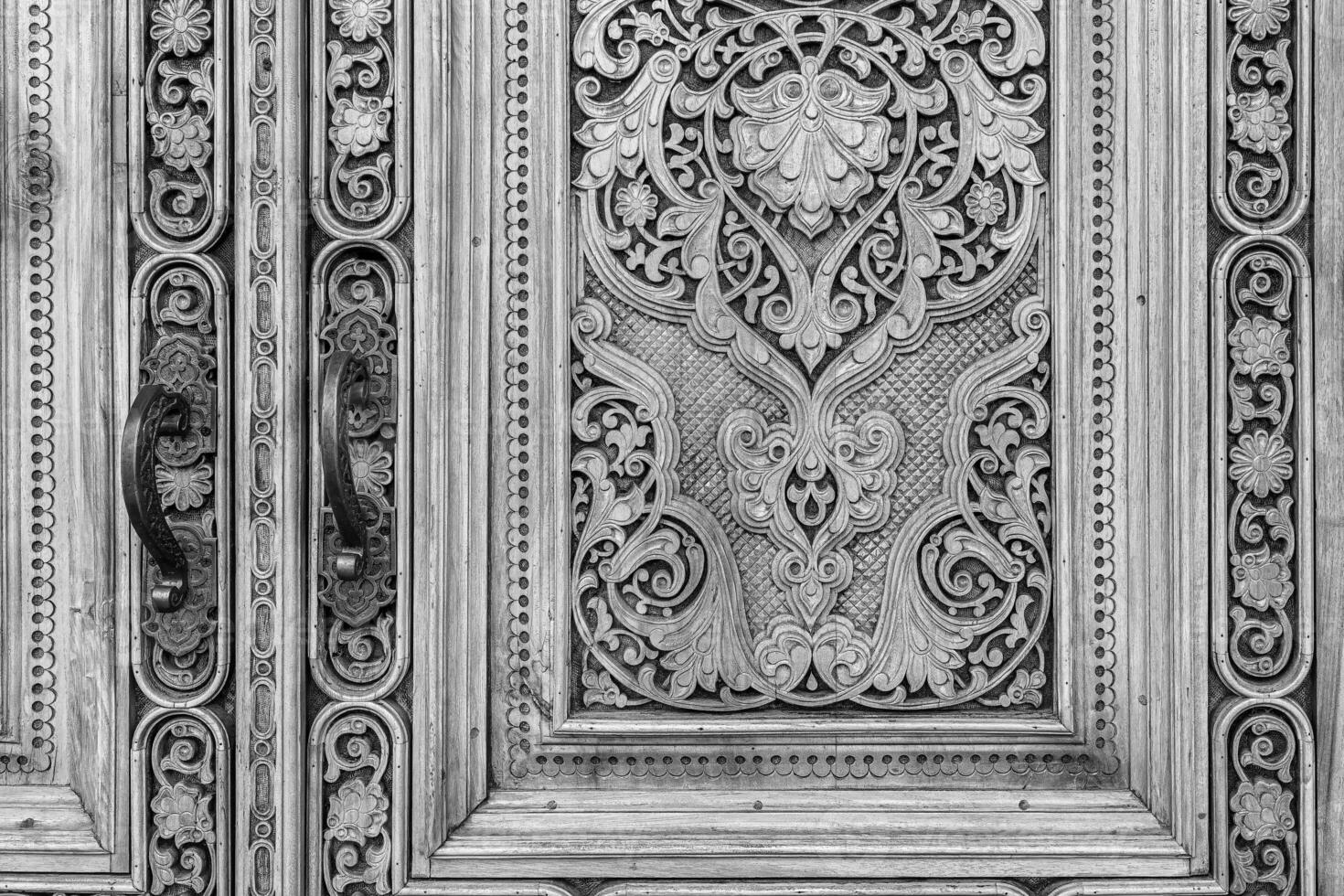 Preto e branco fragmento do a antigo esculpido de madeira porta. ornamentado. foto