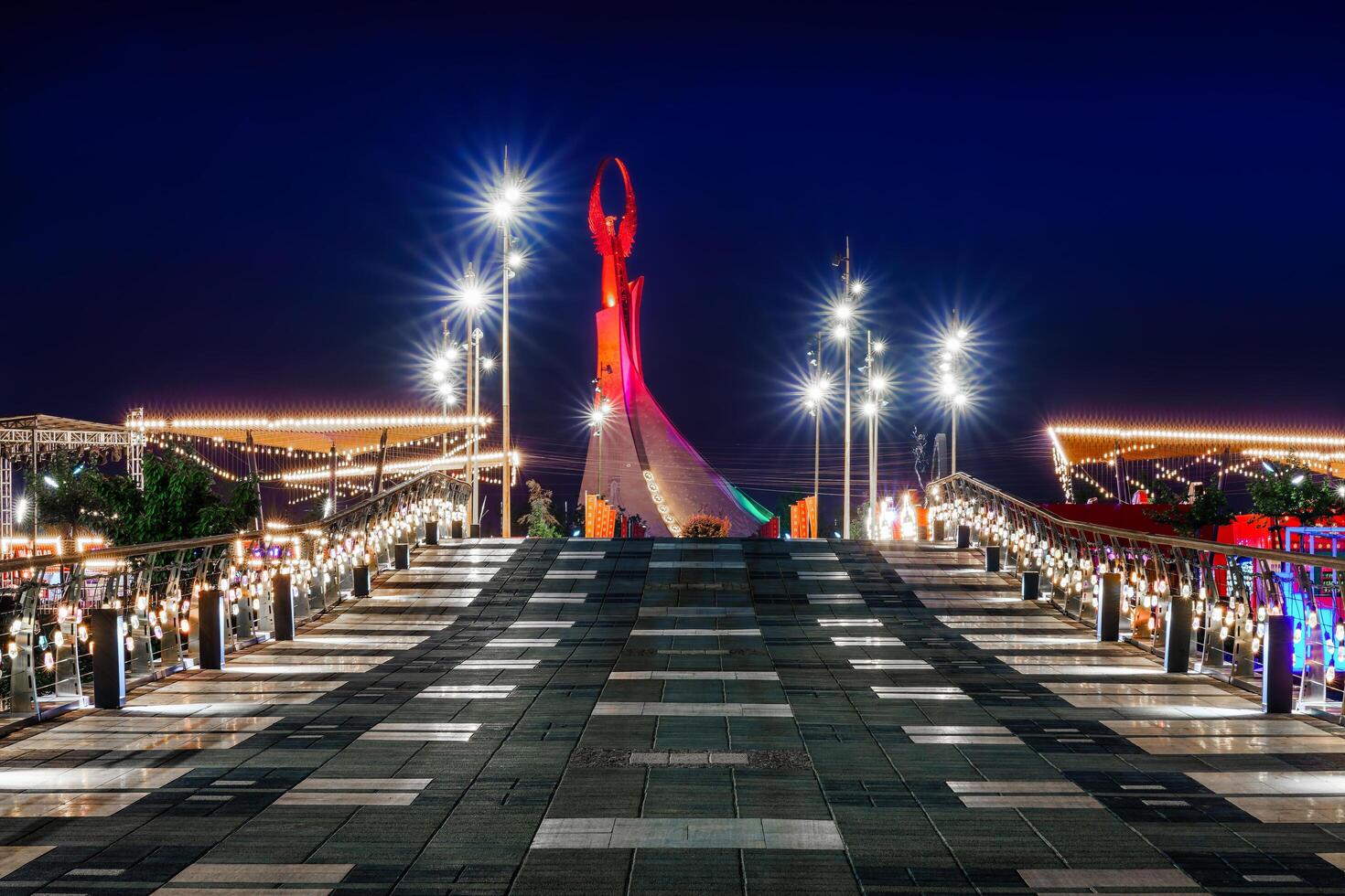 uzbequistão, Tashkent - abril 25, 2023 iluminado monumento do independência dentro a Formato do uma estela com uma humo pássaro dentro a Novo uzbequistão parque às período noturno. Visão a partir de a ponte. foto