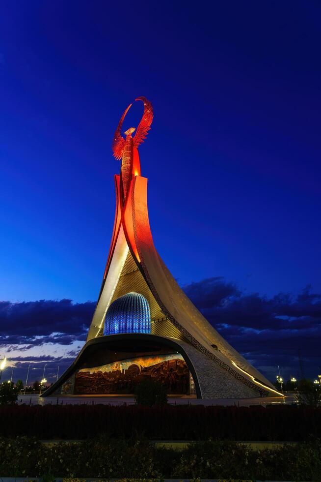 uzbequistão, Tashkent - Outubro 4, 2023 iluminado monumento do independência dentro a Formato do uma estela com uma humo pássaro dentro a Novo uzbequistão parque às período noturno dentro outono. foto