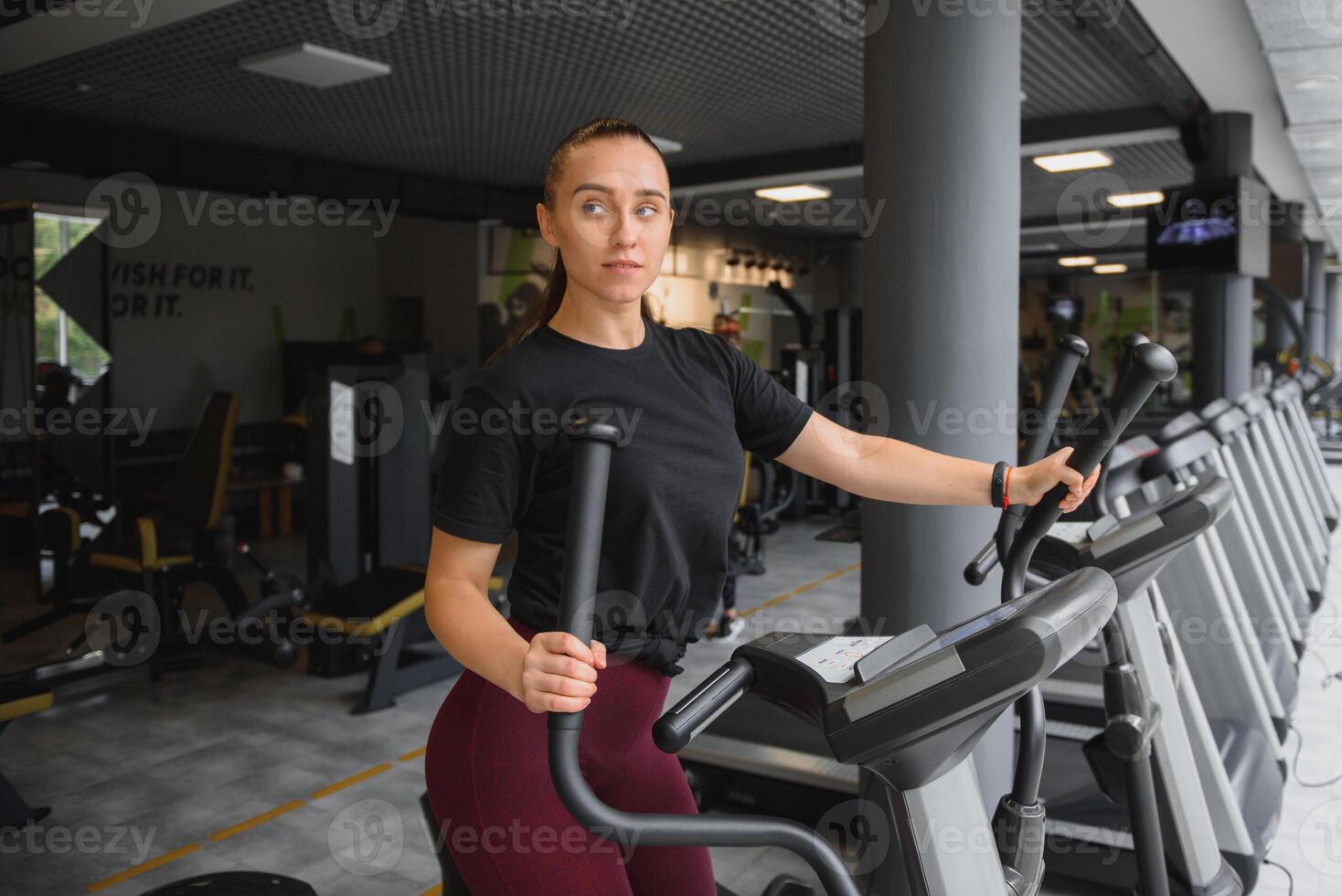 atraente jovem mulher corre em uma esteira, é acionado dentro ginástica esporte clube. foto