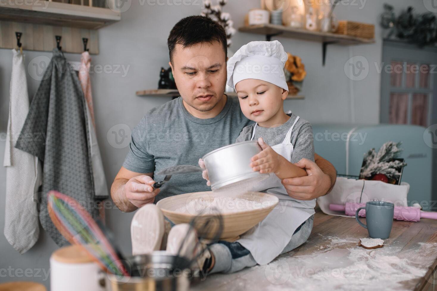 jovem homem e dele filho com forno Folha dentro cozinha. pai com pequeno filho em a cozinha. foto